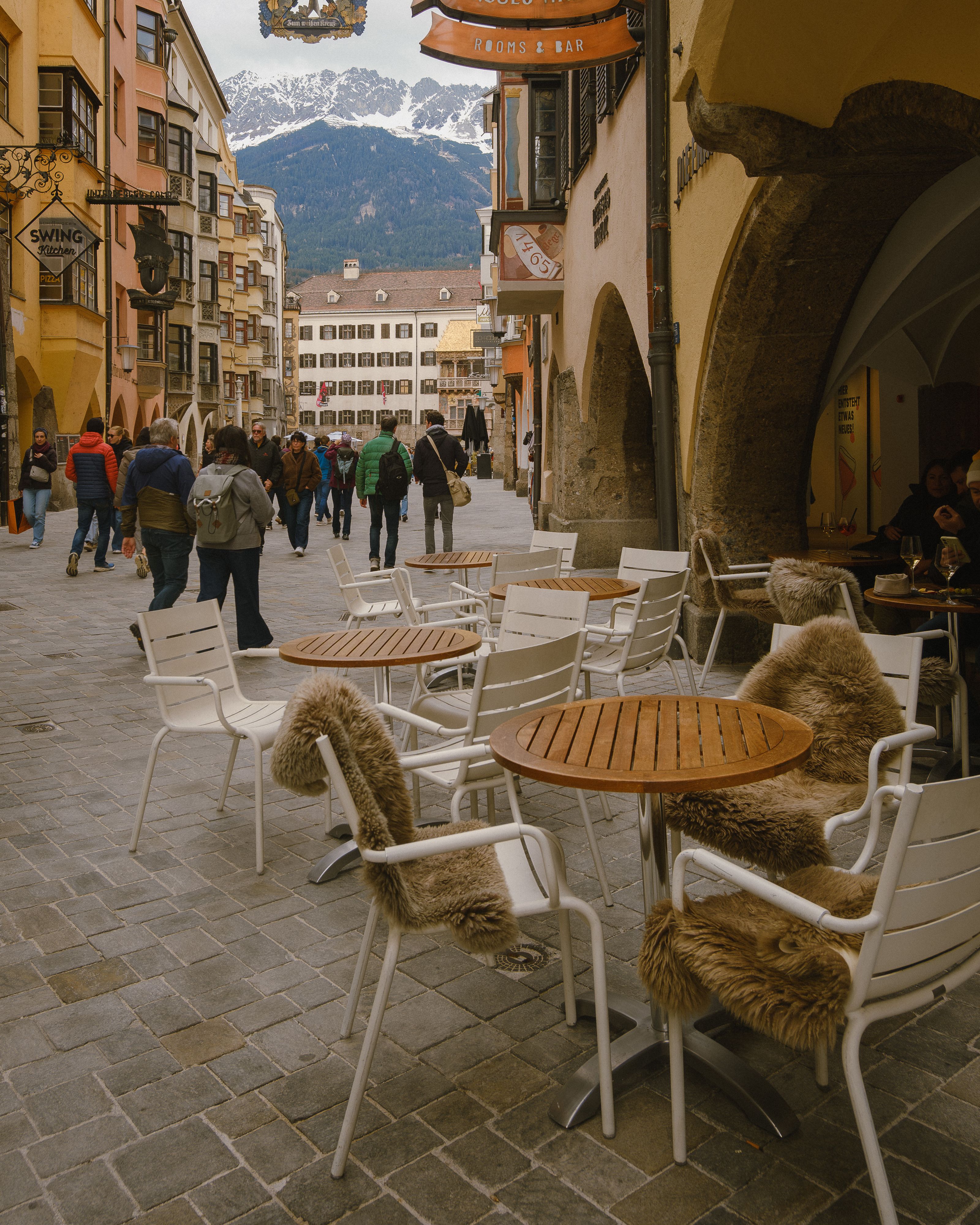 Innsbrucker Gasse mit Tischen und Nordkette